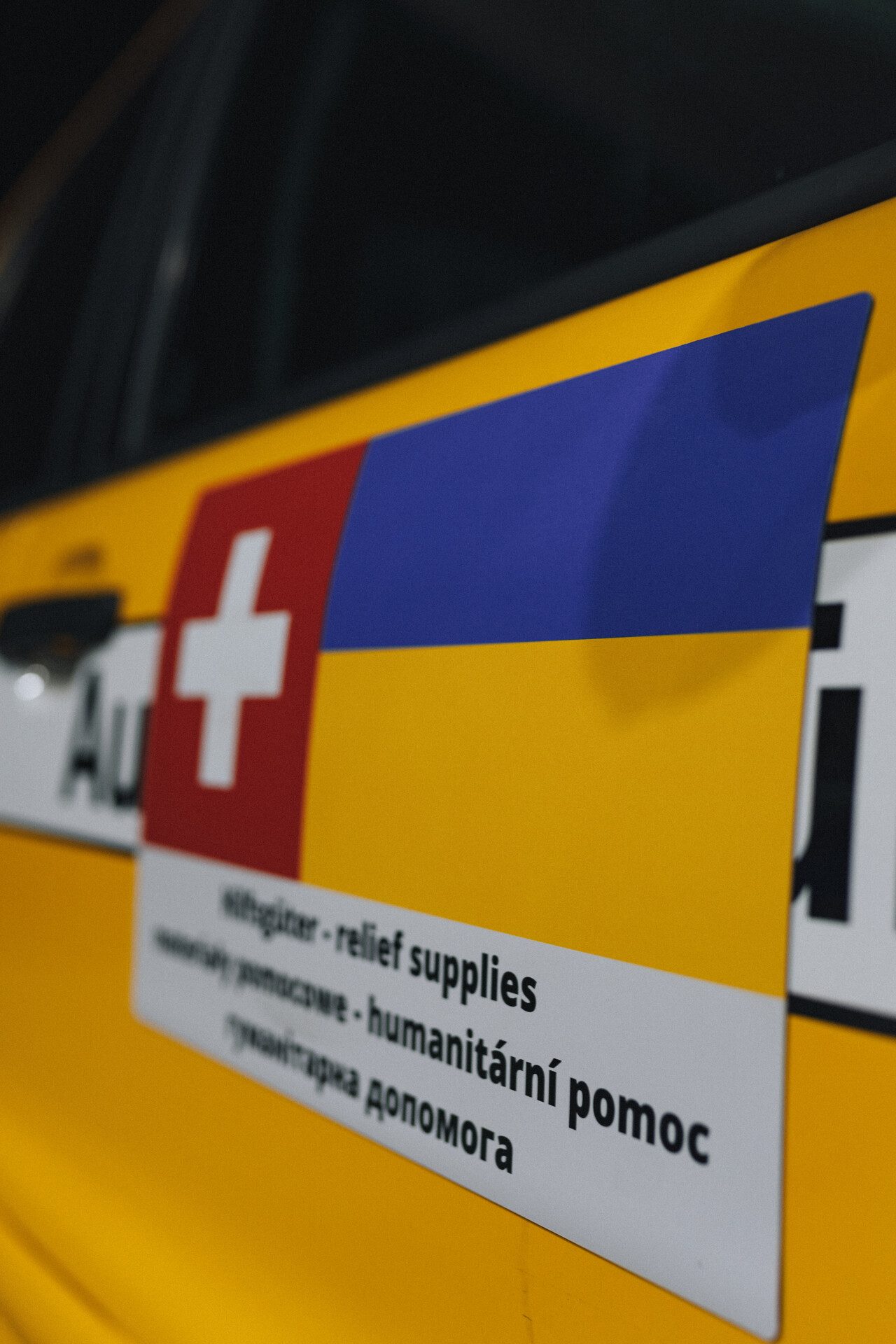 Fahrzeugbeschriftung mit Schweizerkreuz und ukrainischer Flagge